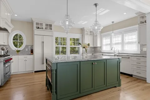 a kitchen with stainless steel appliances granite countertop a stove a sink and a wooden floors