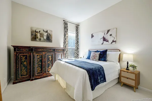 a spacious bedroom with a bed and a painting on the wall