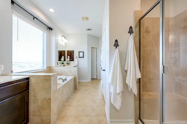 a spacious bathroom with a tub sink and mirror