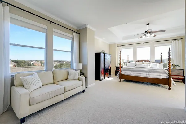 a bedroom with furniture and large windows