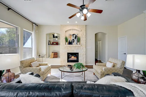 a living room with furniture a fireplace and a large window