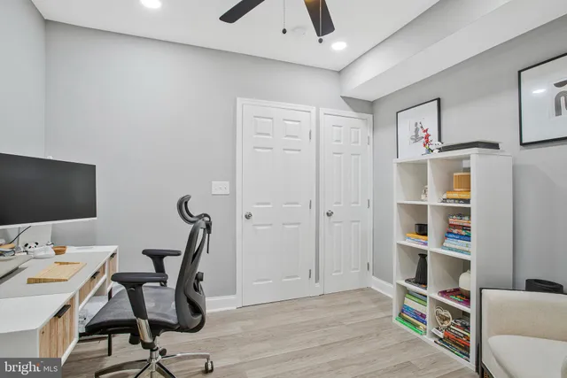 a view of a workspace with furniture and wooden floor