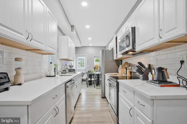 a kitchen with stainless steel appliances kitchen island granite countertop a sink and cabinets