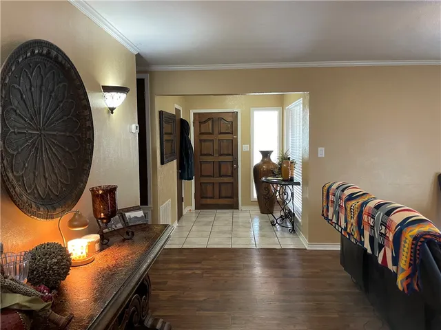 a hallway with a couch and a dining table with wooden floor