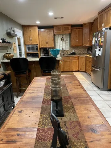 a kitchen with stainless steel appliances kitchen island granite countertop a refrigerator stove microwave and sink