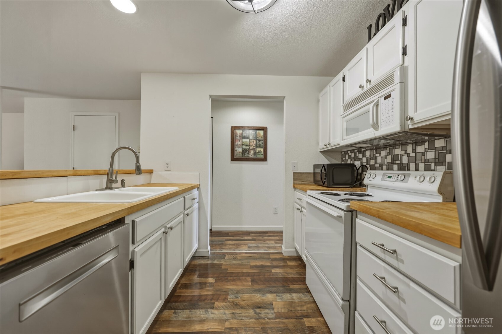 6005 Merlot Lane Southeast Lacey, WA 98513 - Photo 11 of 37 a kitchen with granite countertop a sink and cabinets