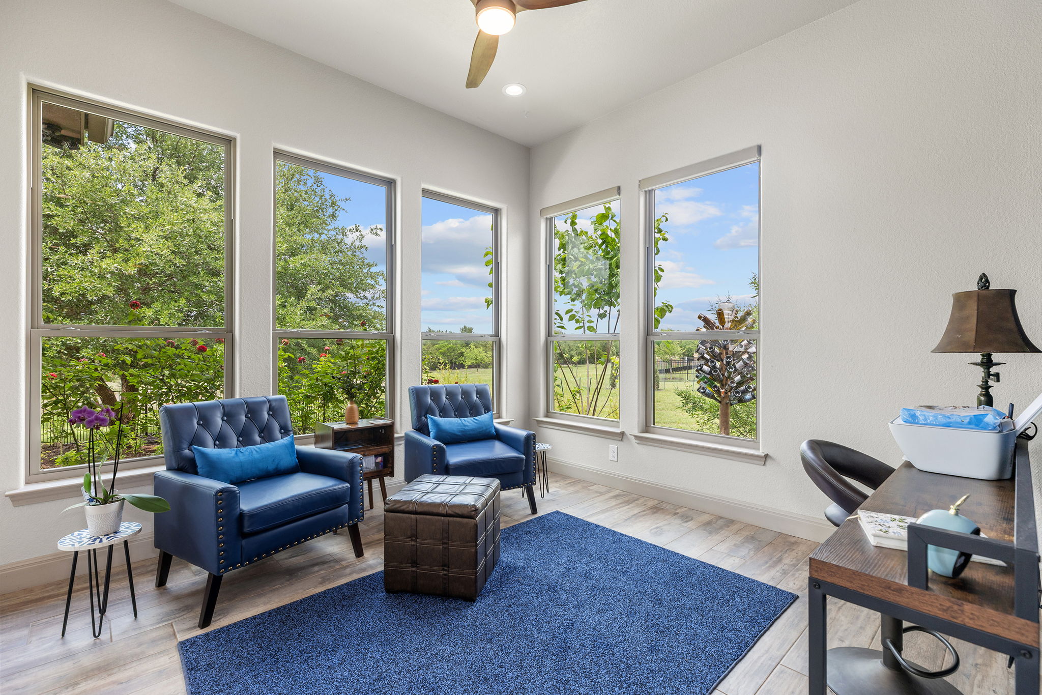 128 Strada Luca Florence, TX 76527 - Photo 12 of 40 Bright room with multiple large windows, wood-look flooring, ceiling fan, and abundant natural light.