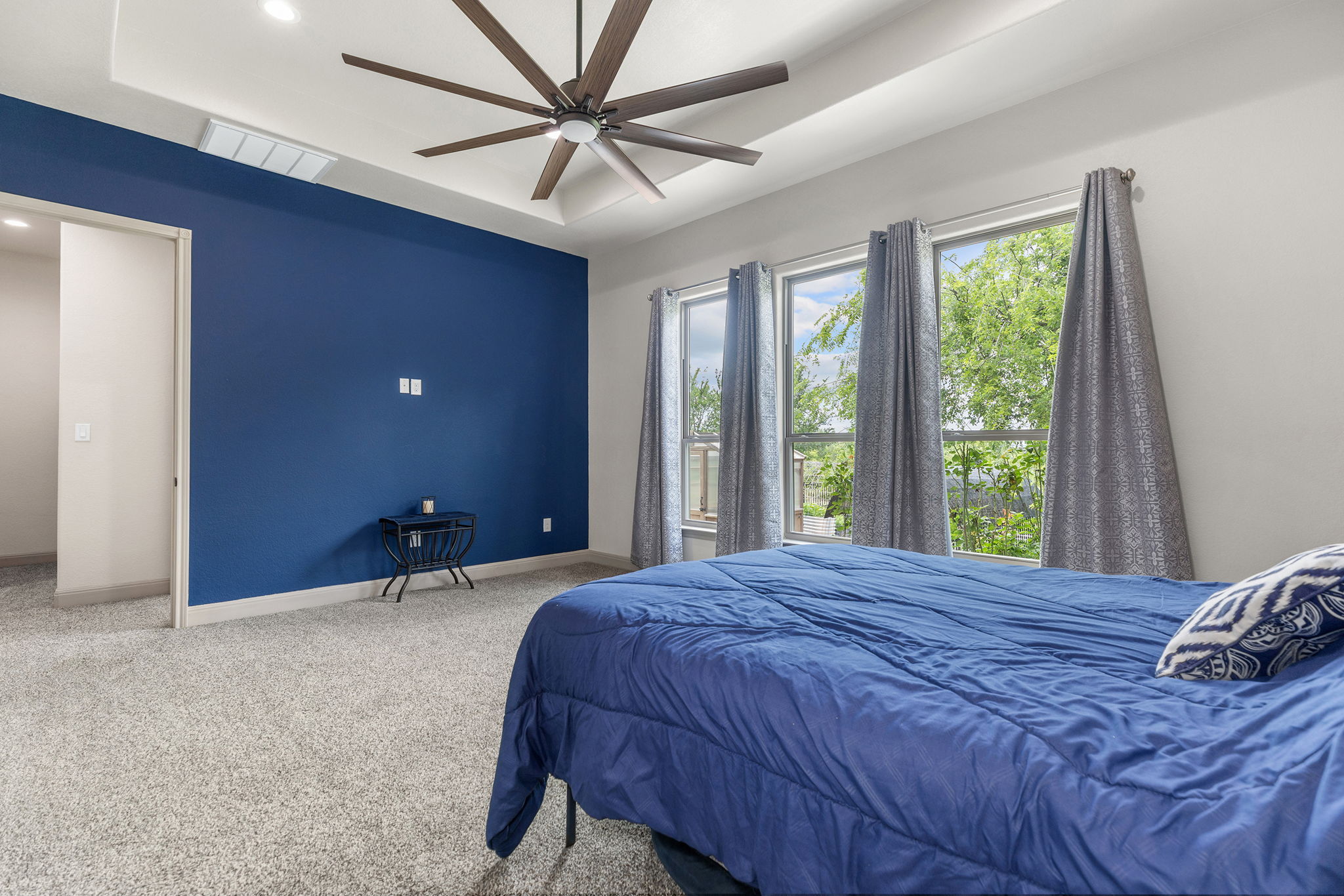 128 Strada Luca Florence, TX 76527 - Photo 16 of 40 Spacious bedroom with tray ceiling, recessed lighting, multi-blade ceiling fan, and large windows for natural light.