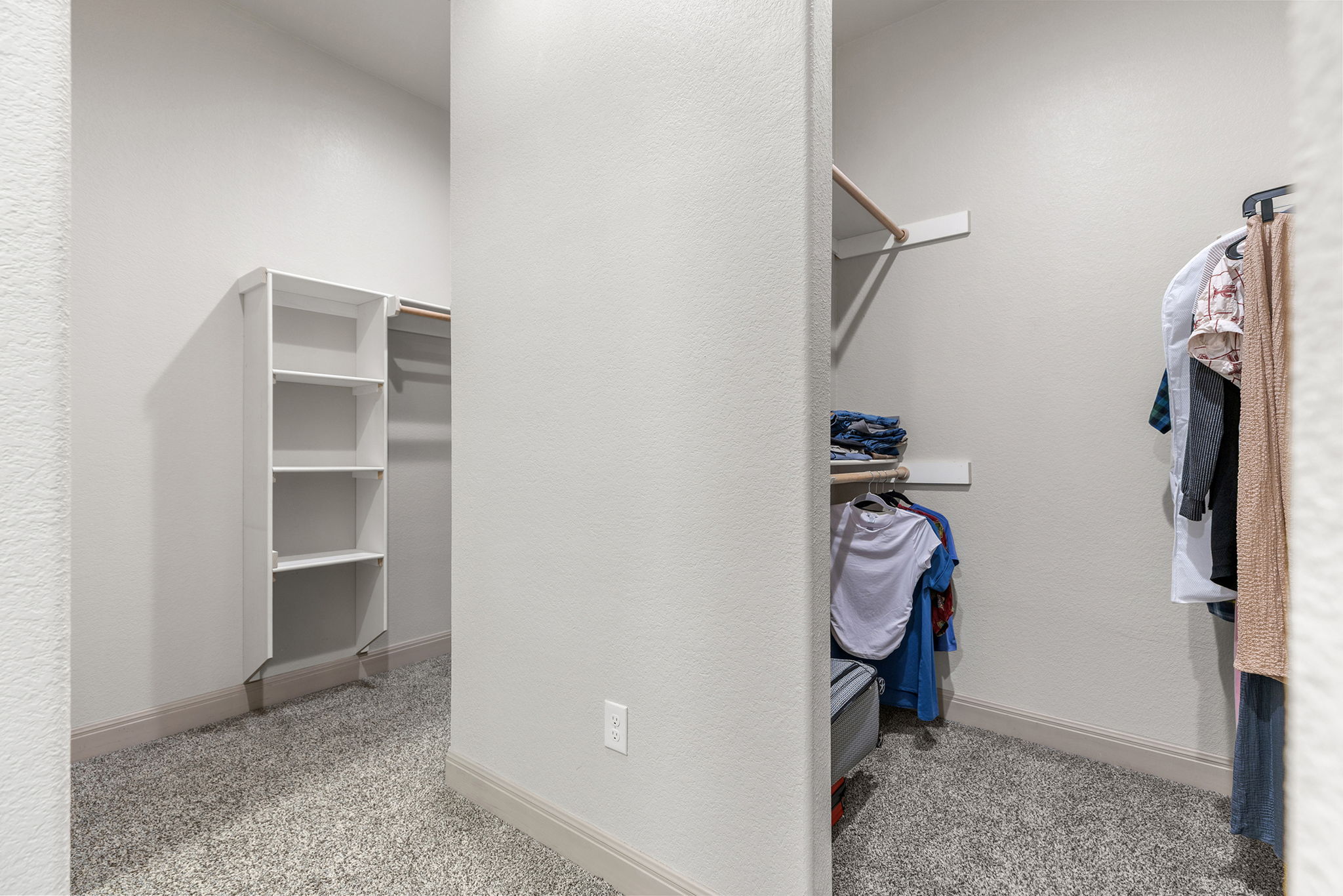 128 Strada Luca Florence, TX 76527 - Photo 21 of 40 Walk-in closet with light carpet, neutral tones, built-in shelving, and dual hanging areas for organized storage.