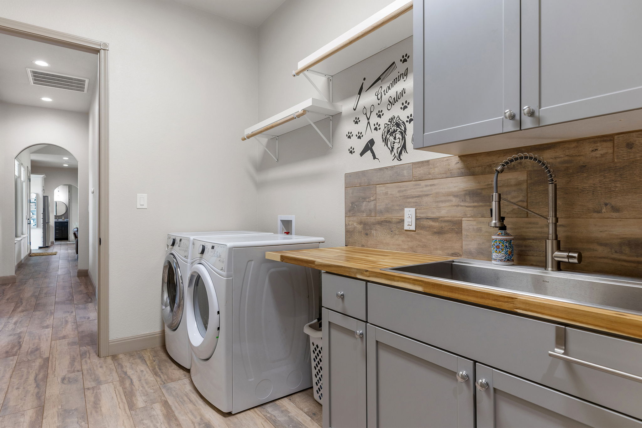 128 Strada Luca Florence, TX 76527 - Photo 22 of 40 Dedicated laundry room with wood-look flooring, utility sink with gooseneck faucet, gray cabinetry, butcher block countertop, and built-in shelving.