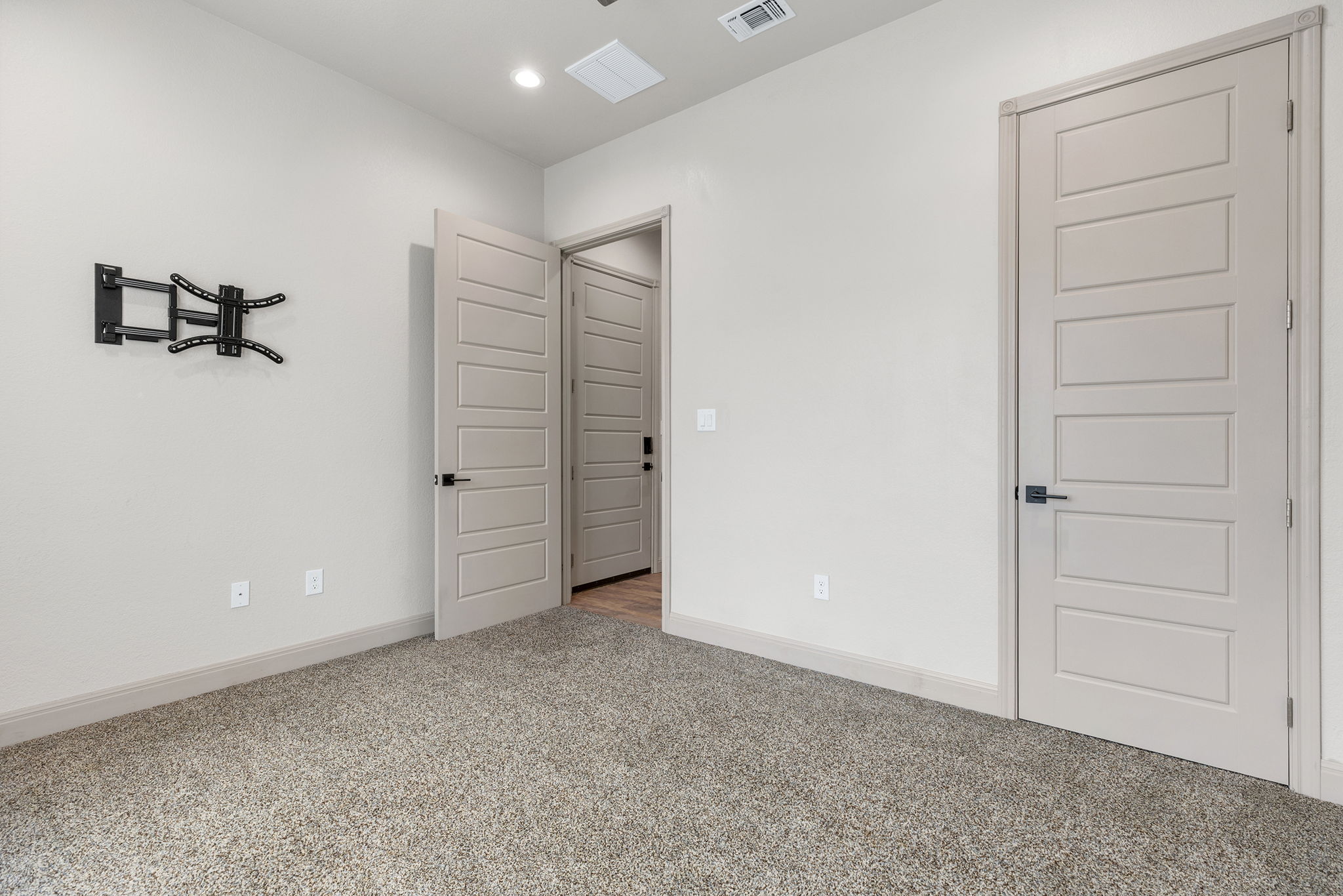 128 Strada Luca Florence, TX 76527 - Photo 24 of 40 Room with light carpet, neutral tones, matching baseboards, and modern paneled doors with black hardware.