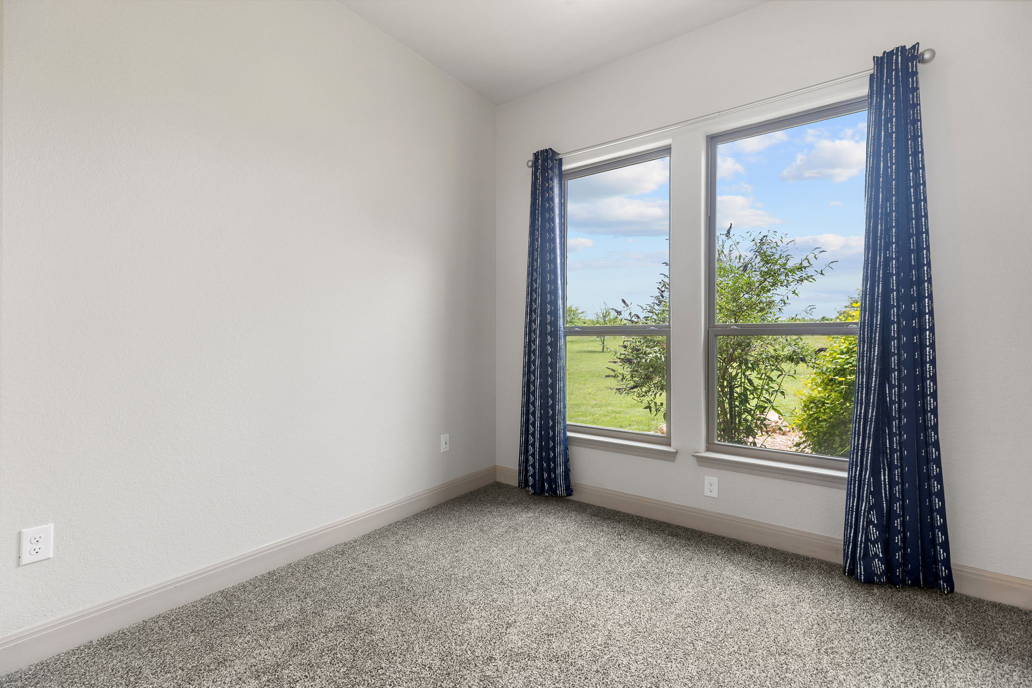 128 Strada Luca Florence, TX 76527 - Photo 26 of 40 Room with dual windows overlooking the yard, light gray walls, gray carpet, and matching baseboards for a clean, neutral finish.