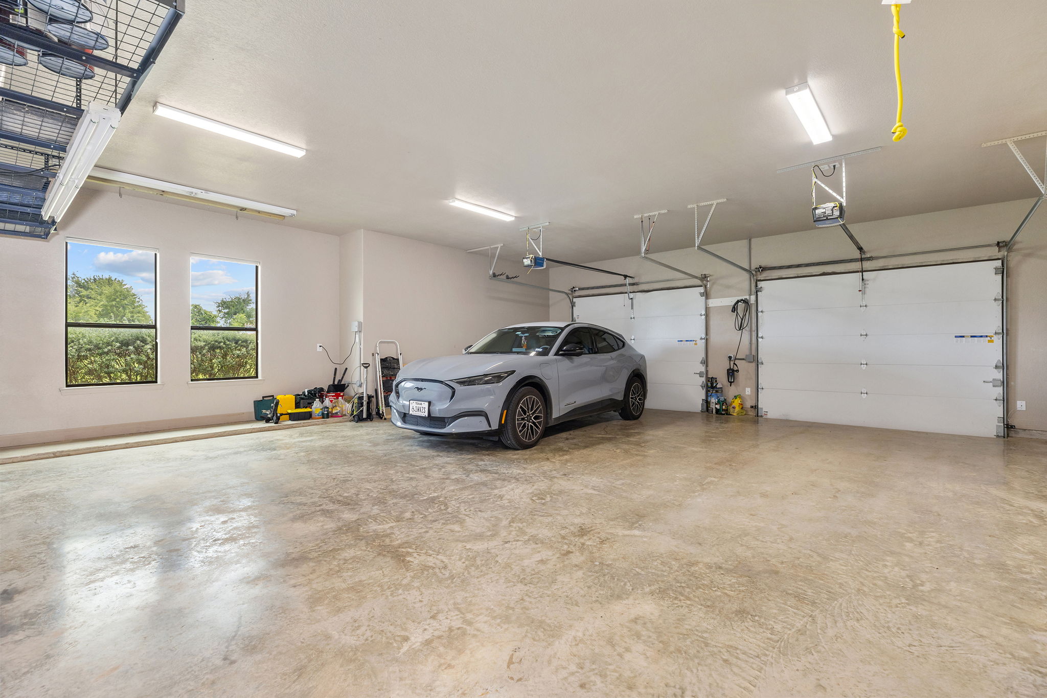 128 Strada Luca Florence, TX 76527 - Photo 29 of 40 Spacious multi-car garage with polished concrete flooring, overhead lighting, and dual garage doors for ample parking and storage.