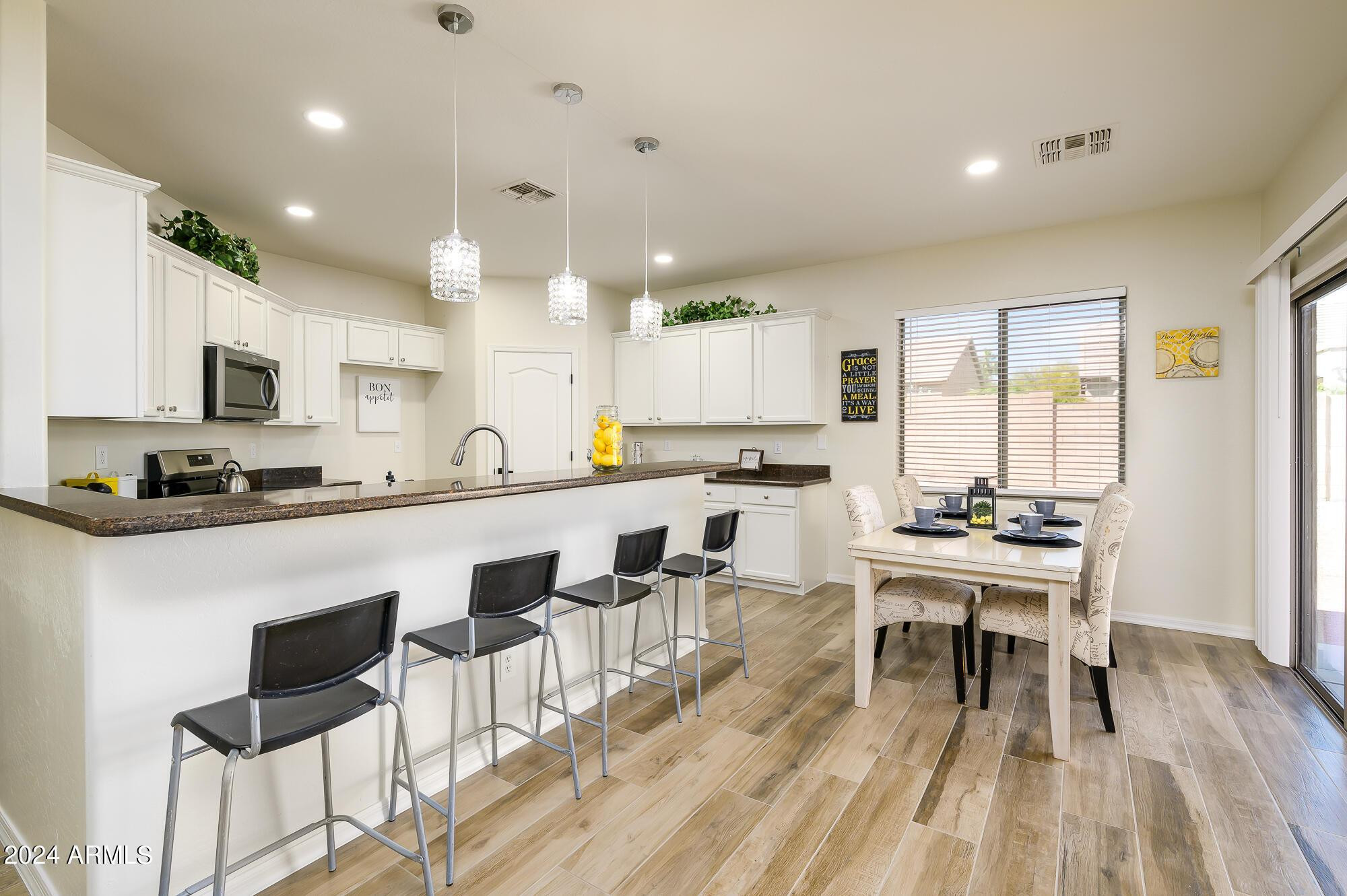 17618 West Crocus Drive Surprise, AZ 85388 - Photo 11 of 34 a kitchen with stainless steel appliances a dining table chairs stove a refrigerator and cabinets