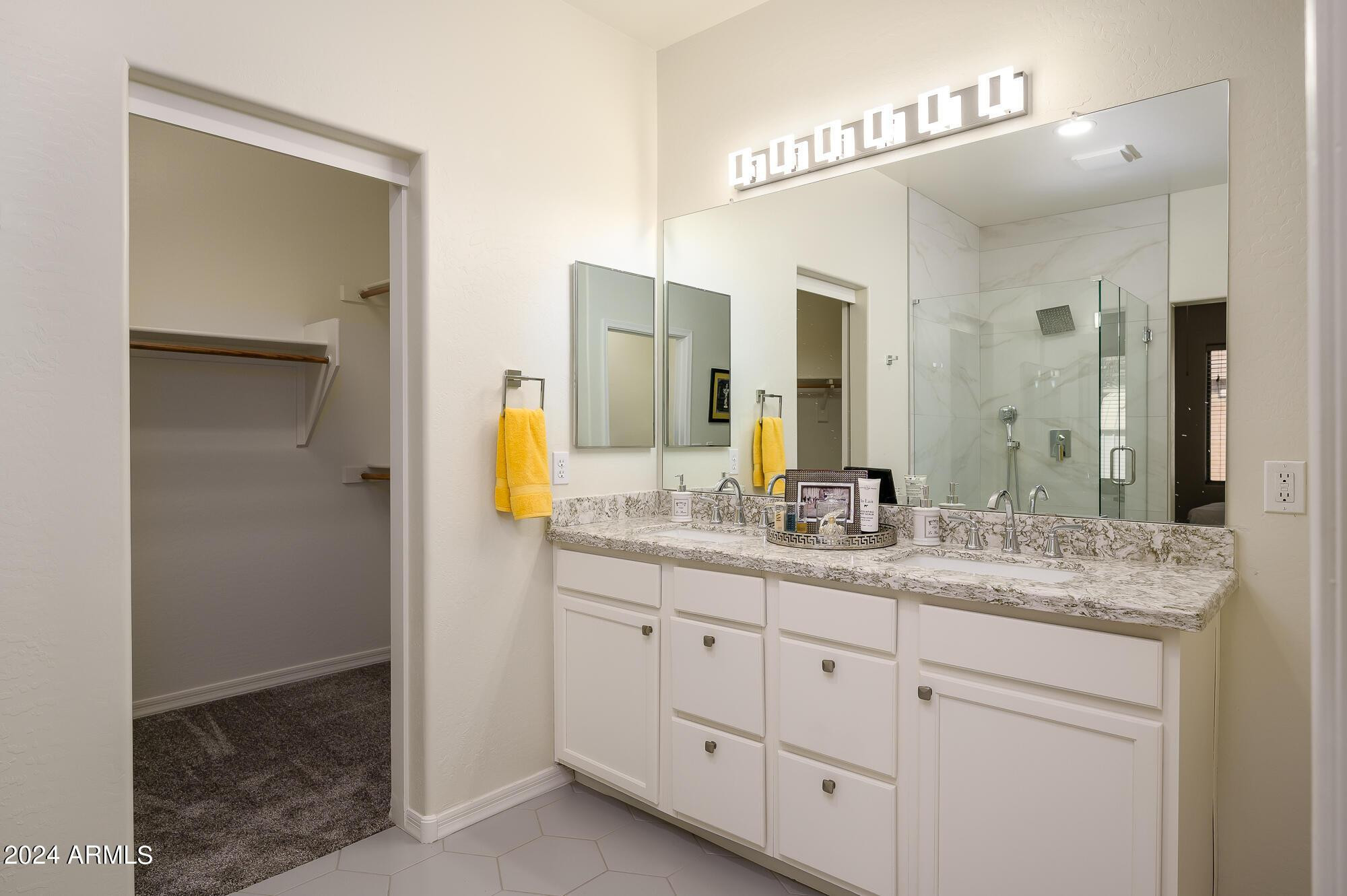 17618 West Crocus Drive Surprise, AZ 85388 - Photo 21 of 34 a bathroom with a granite countertop sink and a mirror