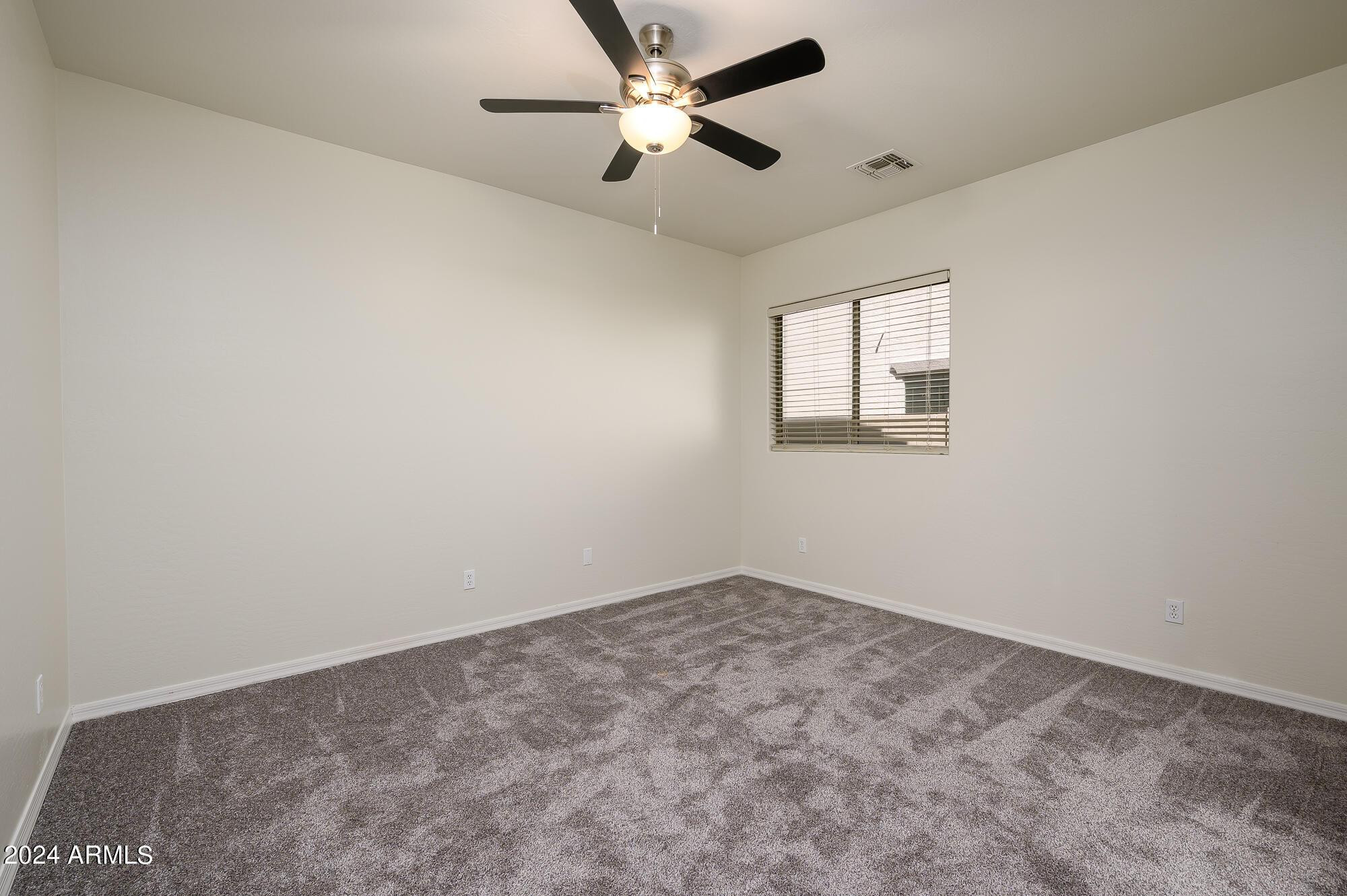 17618 West Crocus Drive Surprise, AZ 85388 - Photo 25 of 34 an empty room with a window and a fan