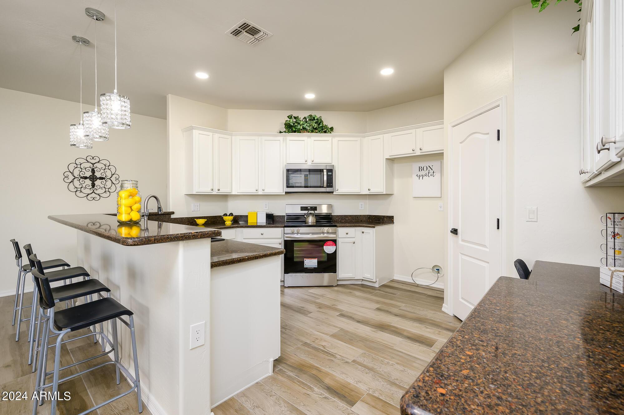 17618 West Crocus Drive Surprise, AZ 85388 - Photo 8 of 34 a kitchen with stainless steel appliances kitchen island granite countertop a stove a sink and a refrigerator