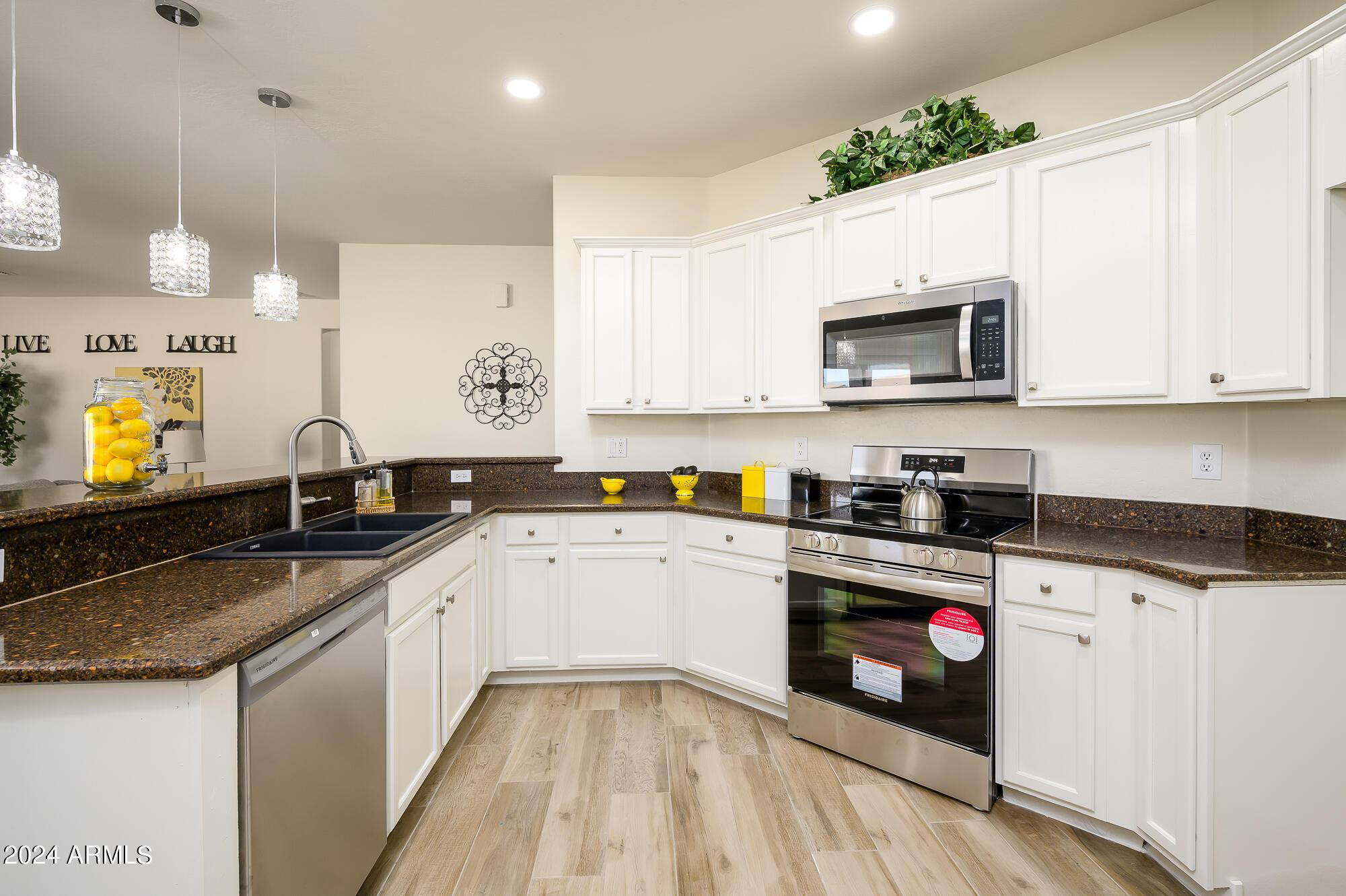 17618 West Crocus Drive Surprise, AZ 85388 - Photo 10 of 34 a kitchen with granite countertop a sink stainless steel appliances and white cabinets