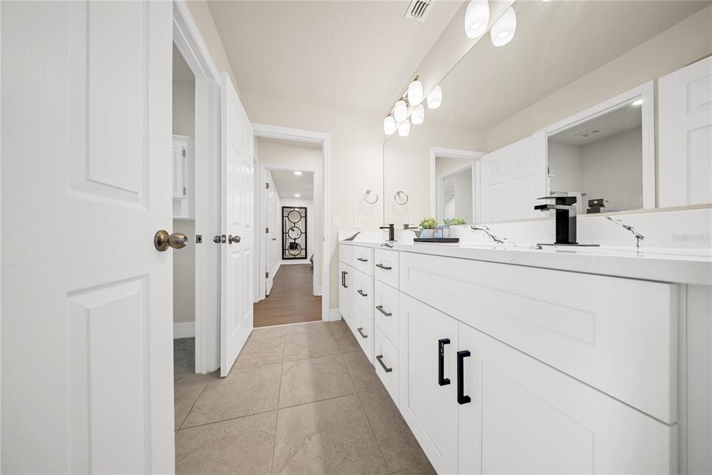 8252 Randal Park Boulevard Orlando, FL 32832 - Photo 35 of 63 a bathroom with a double vanity sink a mirror a vanity and a shower