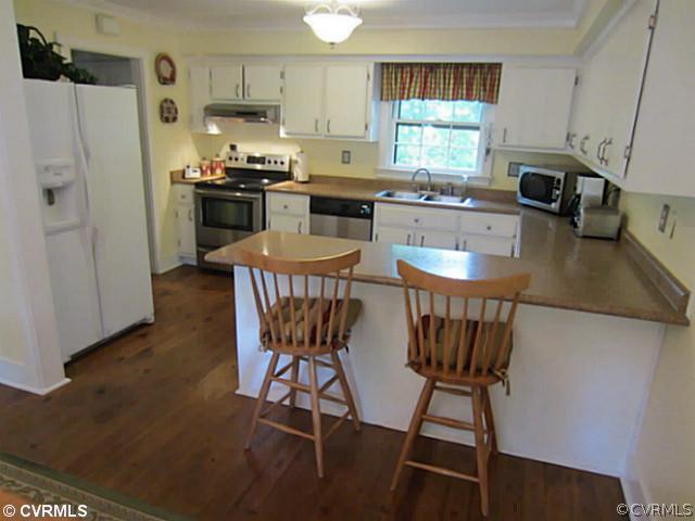 7950 Millvale Road Chesterfield, VA 23832 - Photo 3 of 18 a kitchen with stainless steel appliances granite countertop a stove a refrigerator a white table and chairs with wooden floor