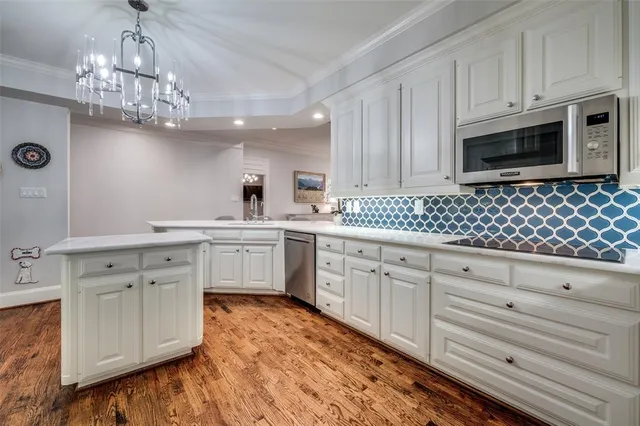 a kitchen with granite countertop a sink stainless steel appliances and cabinets