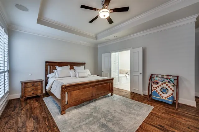 a bedroom with a bed a chair and a potted plant