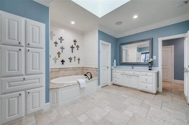 a spacious bathroom with a granite countertop sink mirror and bathtub