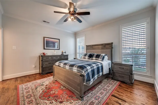a bedroom with a bed and a bookshelf with wooden floor