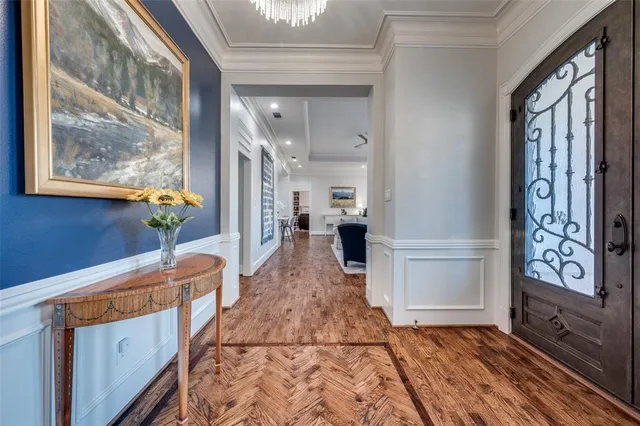 a hallway with painting on the wall and a large window