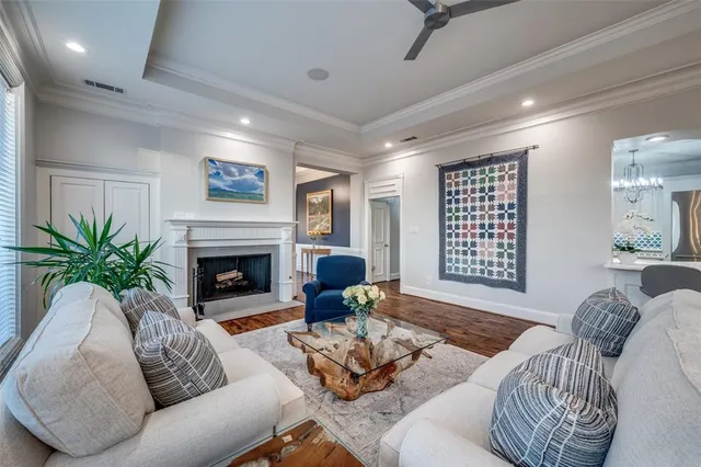 a living room with furniture kitchen view and a wooden floor