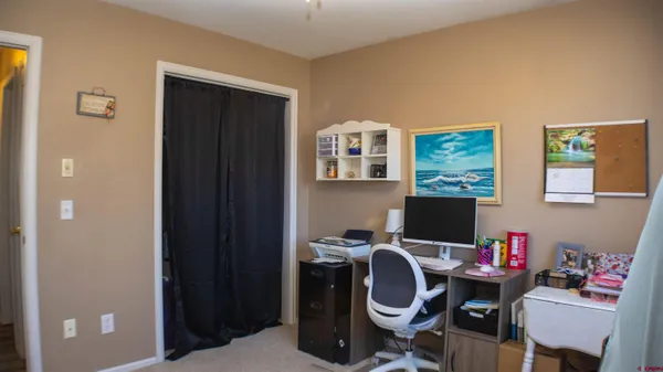 a view of a workspace with furniture and a window