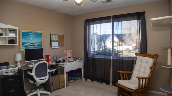 a view of a workspace with furniture and a window