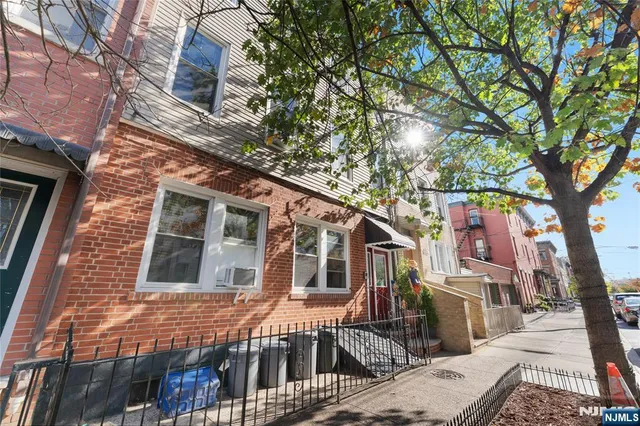 a front view of a house with a tree