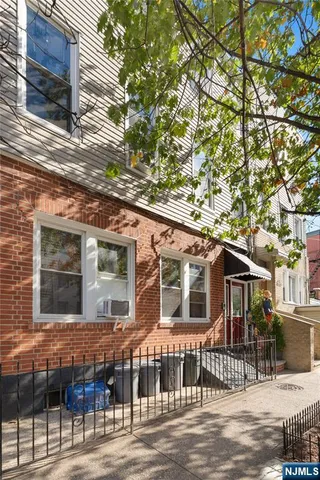 a front view of a house with a tree