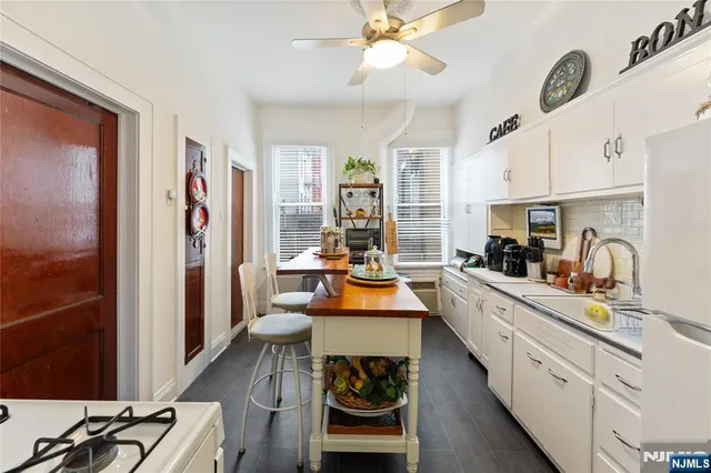 a kitchen with stainless steel appliances granite countertop a refrigerator a stove and a sink with dishwasher next to a window