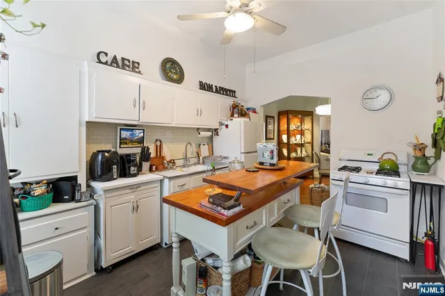a kitchen with a stove a table and chairs in it