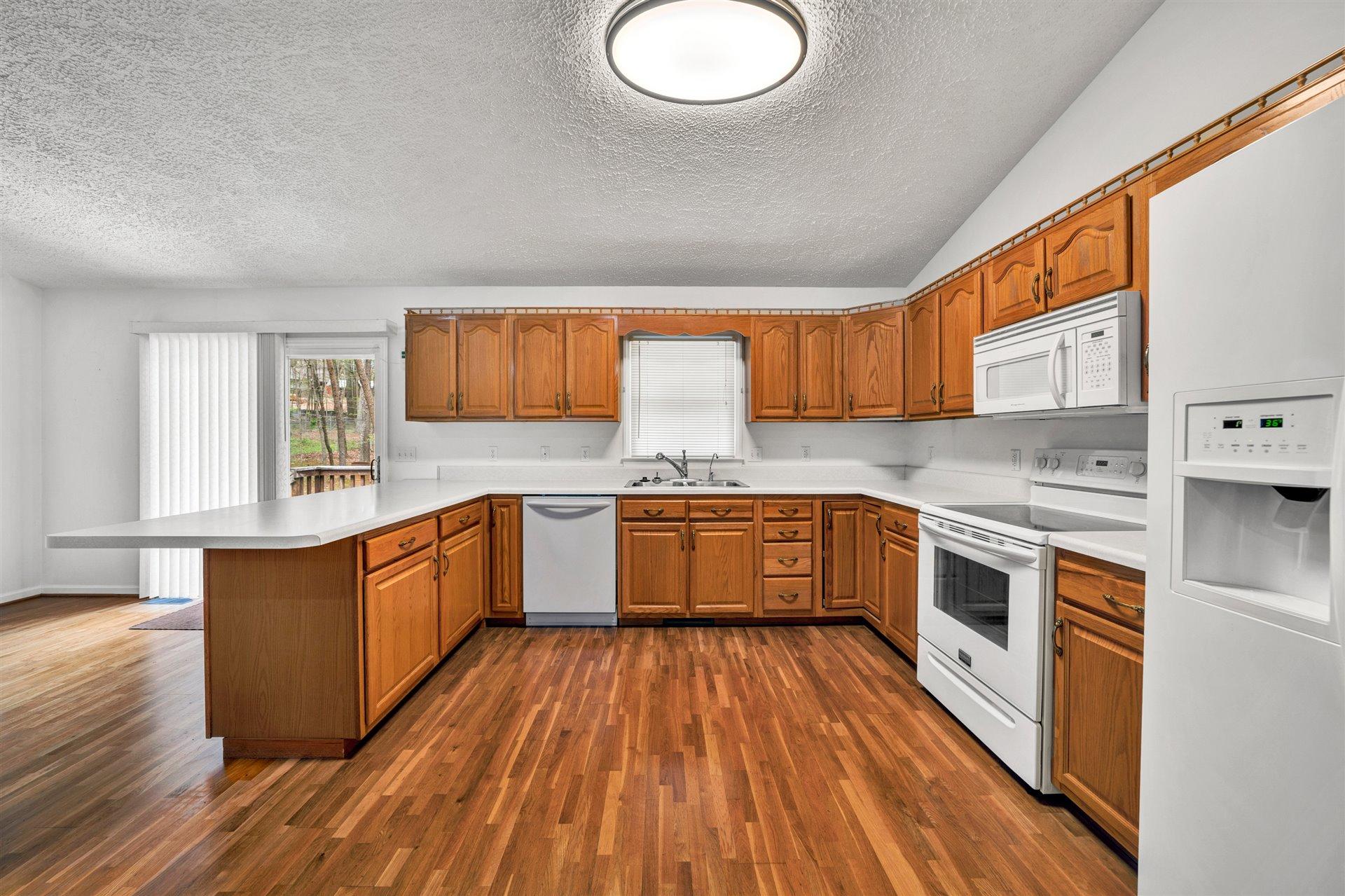 445 Middle Ridge Drive Callaway, VA 24067 - Photo 9 of 25 a kitchen with stainless steel appliances wooden floors and wooden cabinets