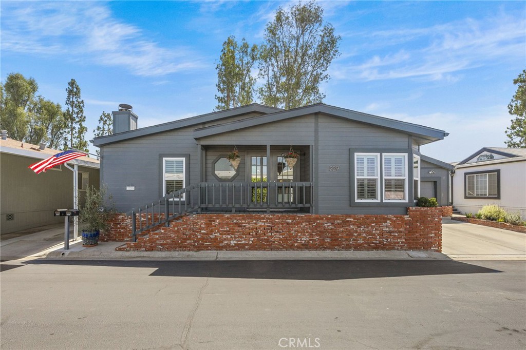 a front view of a house with trees and plants
