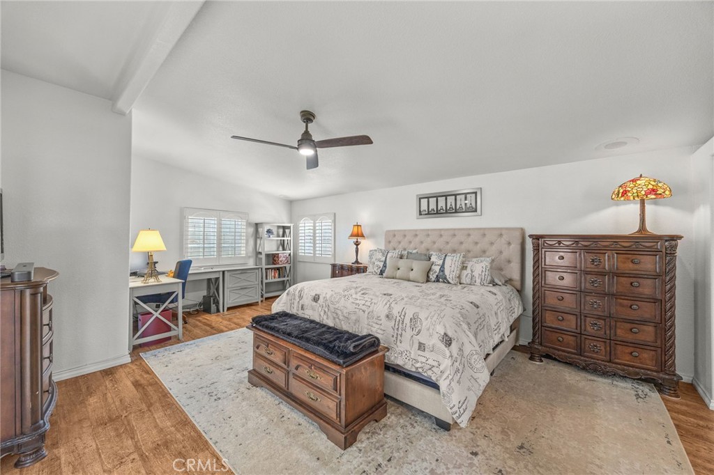 23301 Ridge Rte Drive, Unit 229 Laguna Hills, CA 92653 - Photo 18 of 28 a spacious bedroom with a bed a dresser and a chandelier