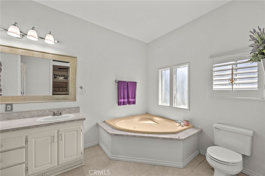 23301 Ridge Rte Drive, Unit 229 Laguna Hills, CA 92653 - Photo 23 of 28 a bathroom with a granite countertop sink mirror vanity bathtub and a toilet