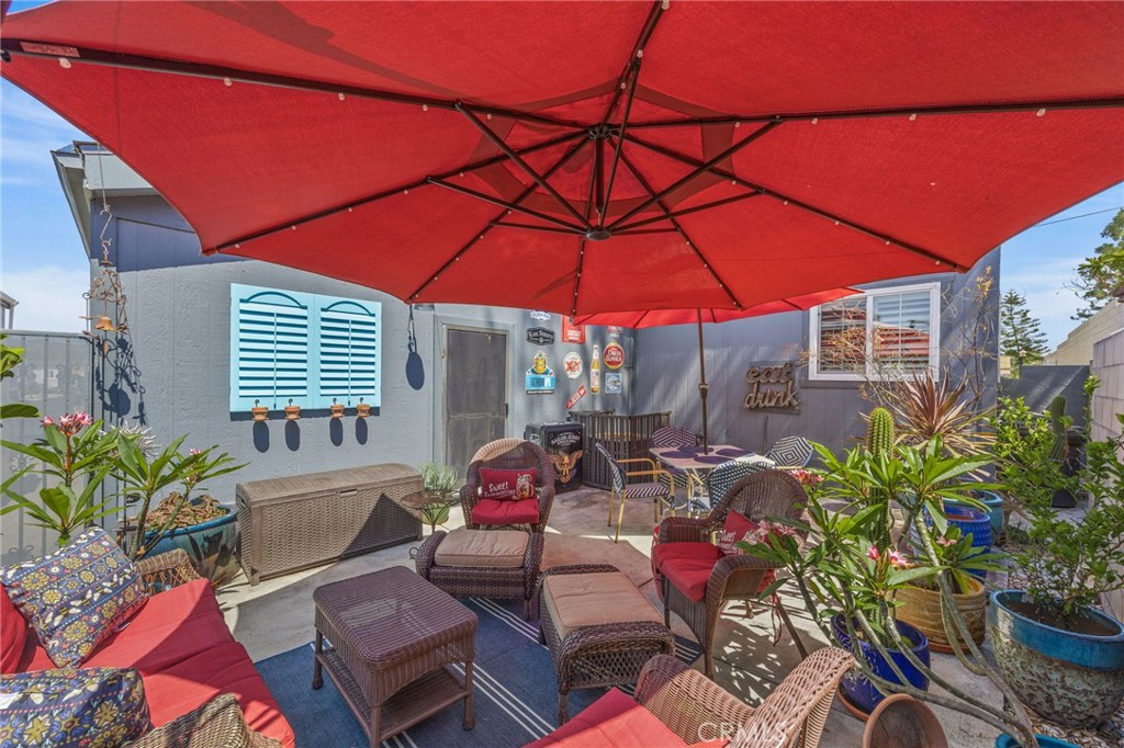 23301 Ridge Rte Drive, Unit 229 Laguna Hills, CA 92653 - Photo 27 of 28 a patio with tables and chairs and a umbrella