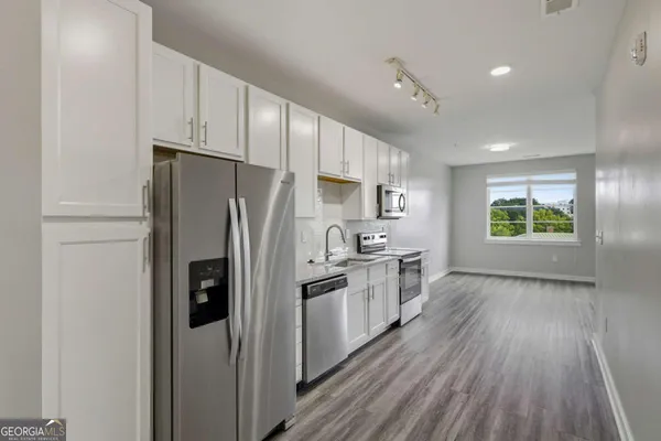 a kitchen with stainless steel appliances a refrigerator and a stove top oven