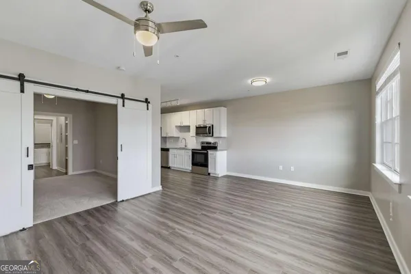 wooden floor in an empty room with a kitchen