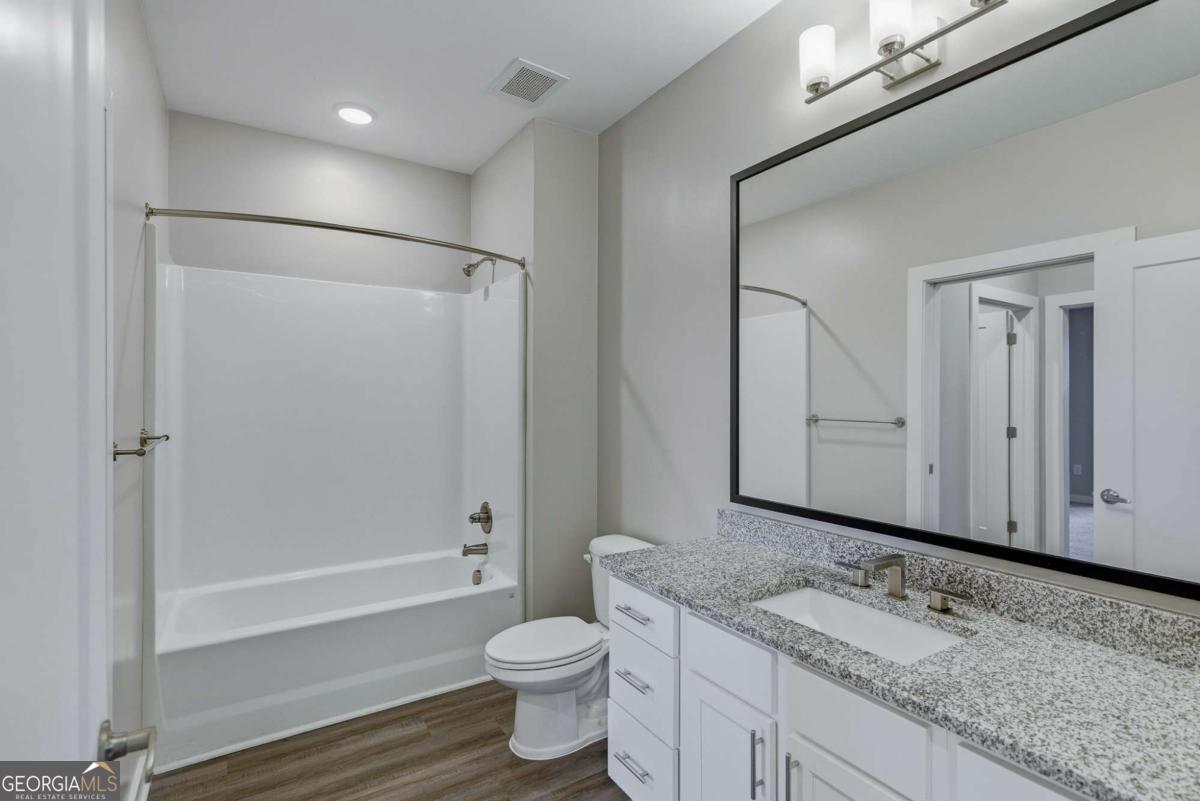 100 Prince Avenue, Unit A407 Athens, GA 30601 - Photo 21 of 27 a bathroom with a granite countertop sink toilet and shower