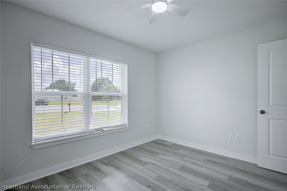 111 Vale Court Sebring, FL 33876 - Photo 23 of 40 a view of an empty room with wooden floor and a window