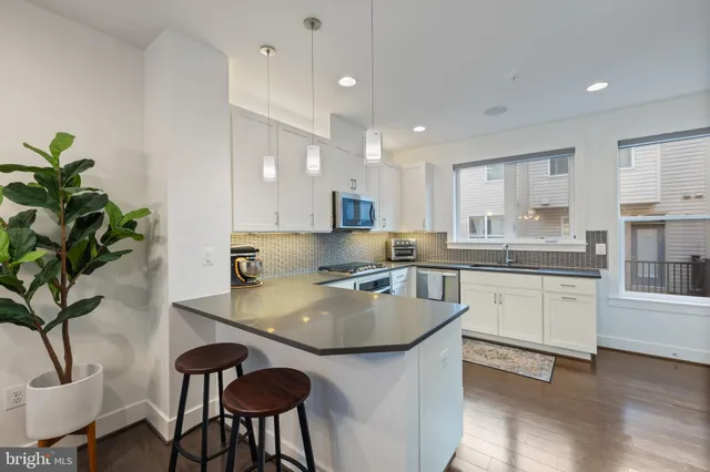 a view of a kitchen with kitchen island a sink a stove and refrigerator