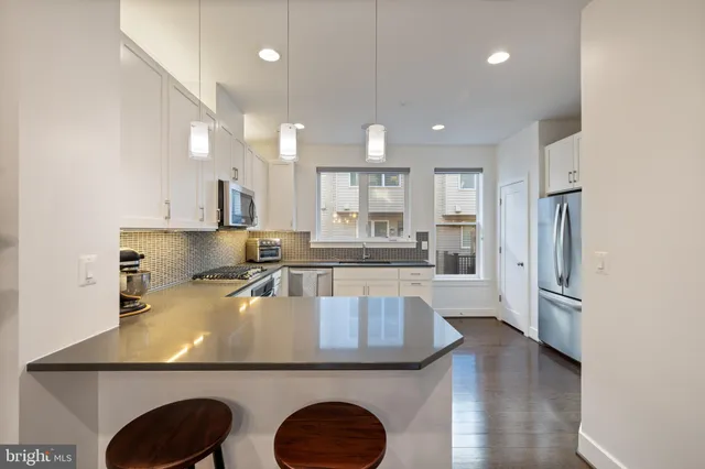 a kitchen with stainless steel appliances kitchen island granite countertop a stove a sink a microwave and a refrigerator