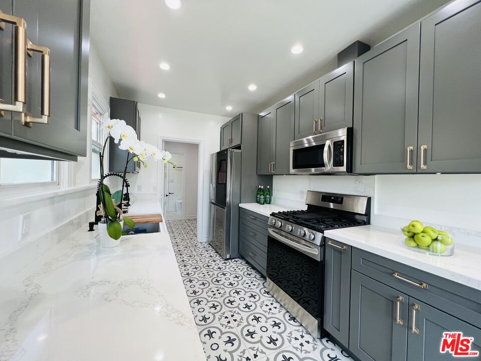 6187 Barrows Drive Los Angeles, CA 90048 - Photo 12 of 35 a kitchen with kitchen island stainless steel appliances a sink stove and cabinets
