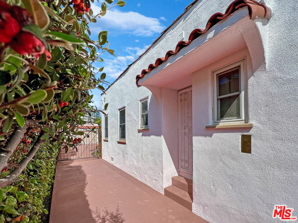 6187 Barrows Drive Los Angeles, CA 90048 - Photo 34 of 35 a front view of a house with a yard