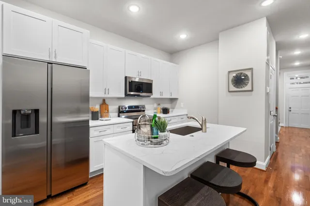 a kitchen with a refrigerator and a stove top oven